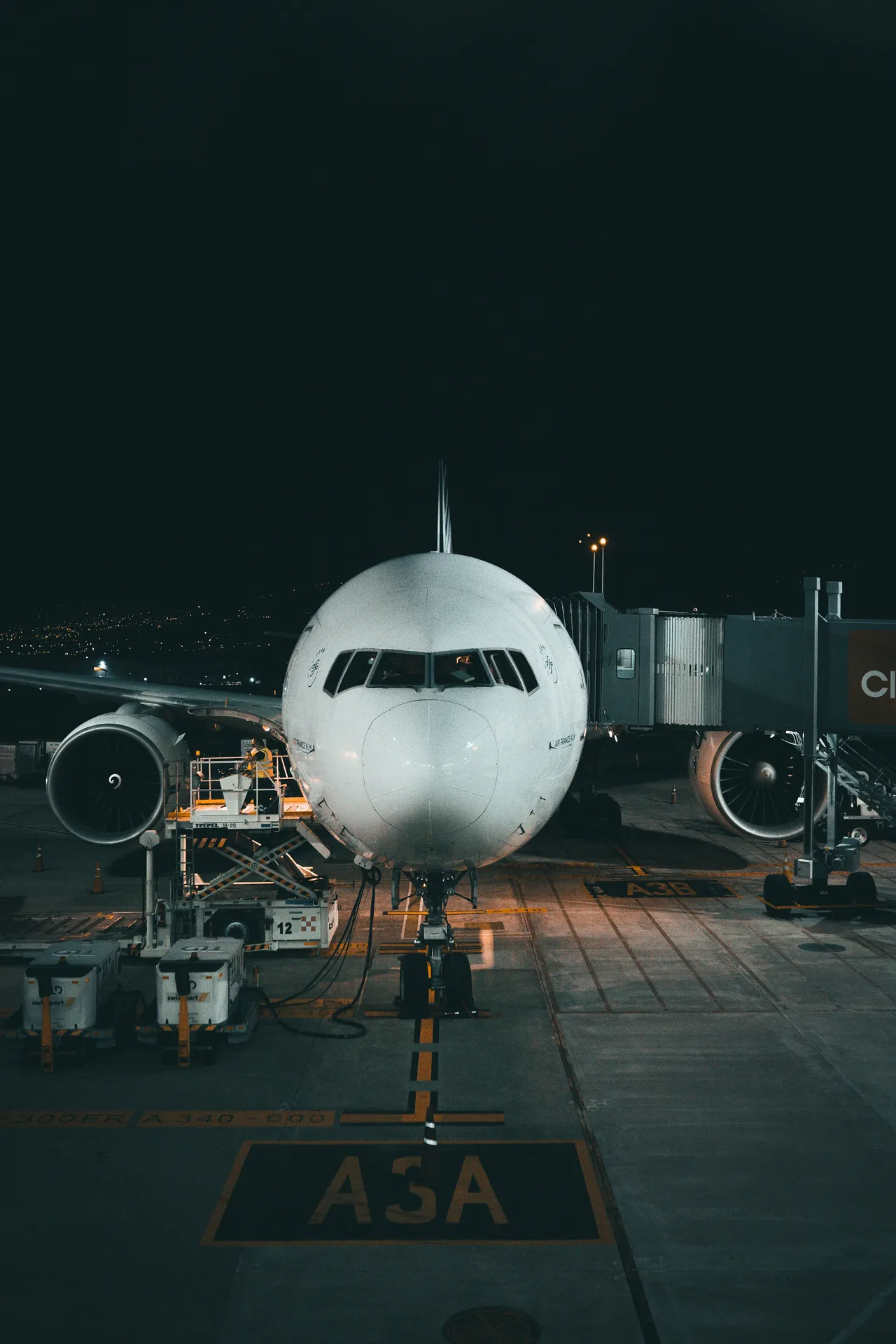 Flugzeug am Gate bei Nacht, Vorfeld mit Abfertigungsgerät